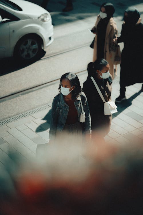Women in Masks on Sidewalk