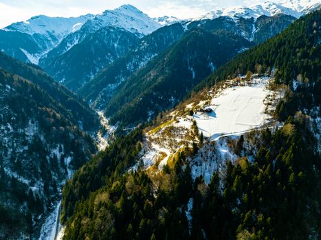 Stunning aerial view of winter landscape in Çamlıhemşin, Türkiye, featuring snow-covered mountains and lush forests.