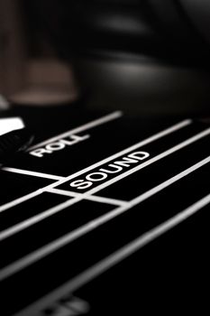 Artistic black and white close-up of a film clapperboard focused on the word 'SOUND'.
