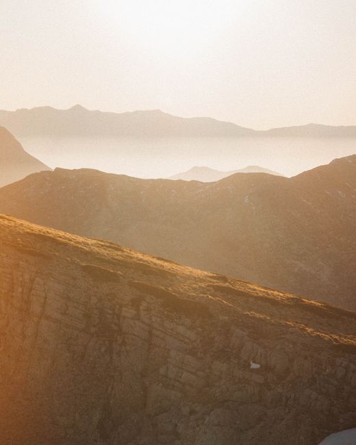 A breathtaking sunrise over a mist-covered mountain range creates a serene landscape.