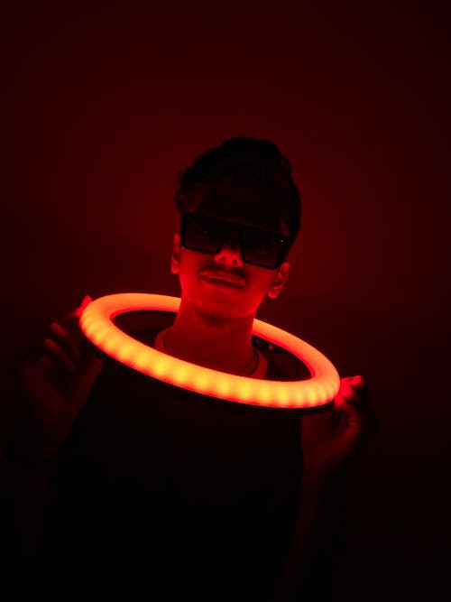 Man in Sunglasses and an Illuminated Hoop on the Neck 
