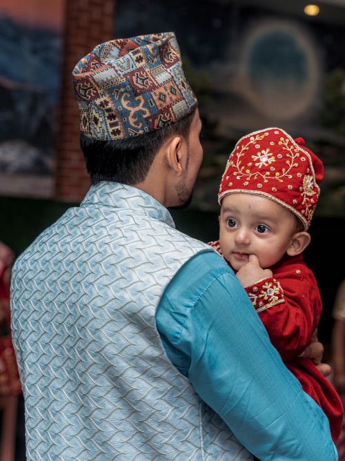 Free A father holding his baby in elaborate traditional clothing, showcasing cultural heritage. Stock Photo