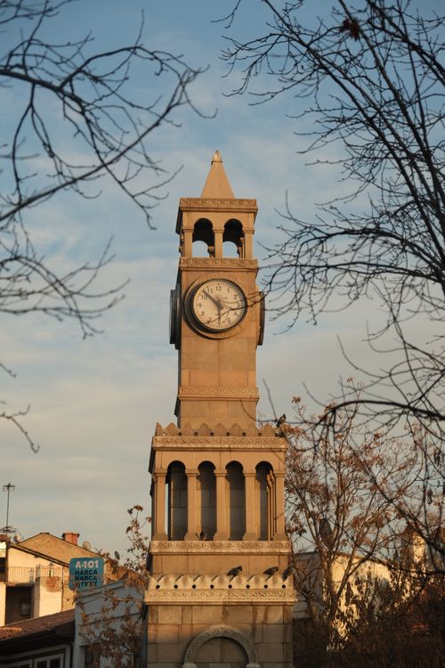 Free A monumental clock tower standing tall amidst barren winter trees in Ankara, Turkey. Stock Photo