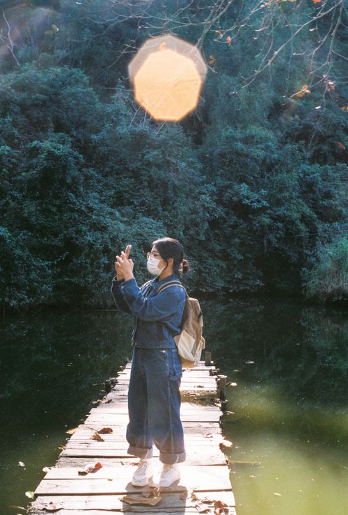 Free Young woman captures a photo on a footbridge in Nghe An, Vietnam. Stock Photo