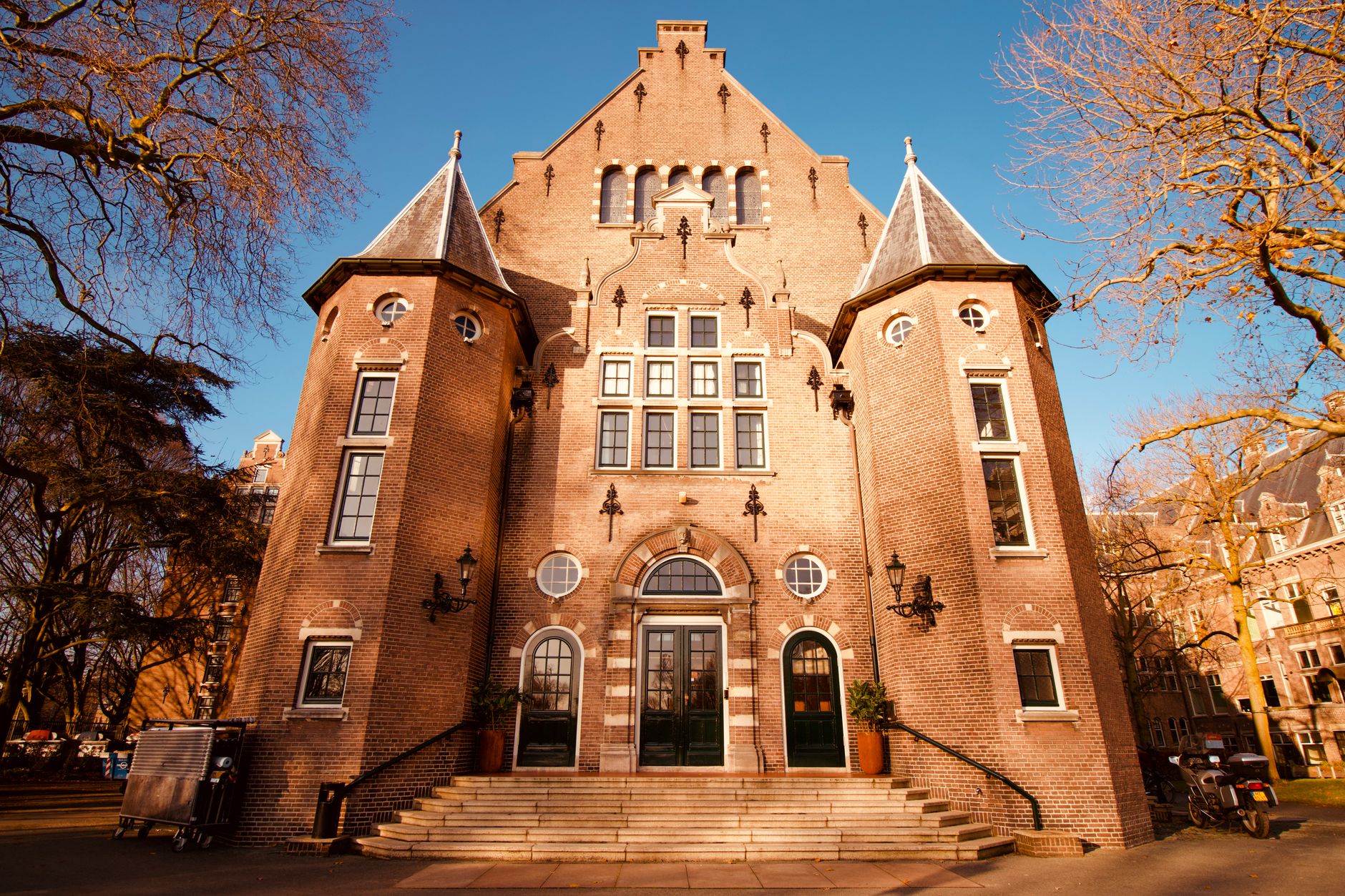Front view of Amsterdam's Royal Tropical Institute, showcasing its historic architecture during a sunny day.