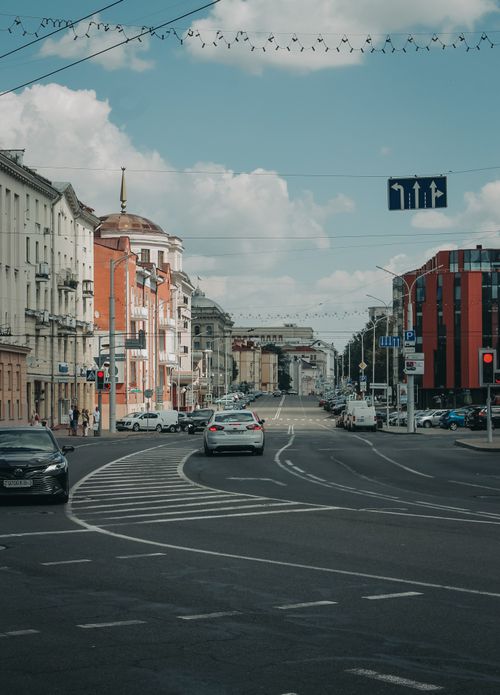 Free A bustling city street in Minsk, Belarus with classic and modern buildings under a clear blue sky. Stock Photo