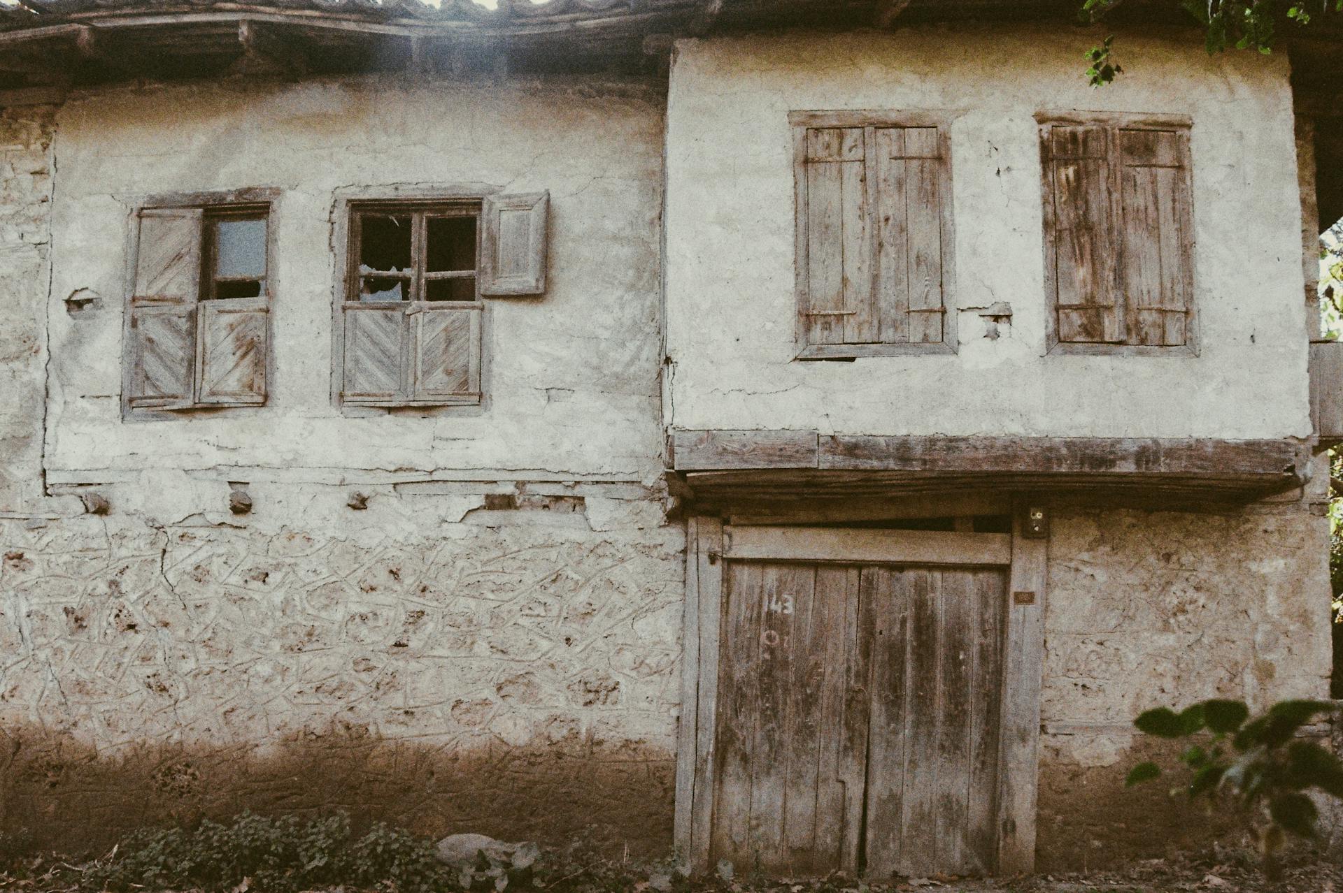 Explore the charm of a rustic, abandoned house with decaying wooden shutters and vintage architecture.