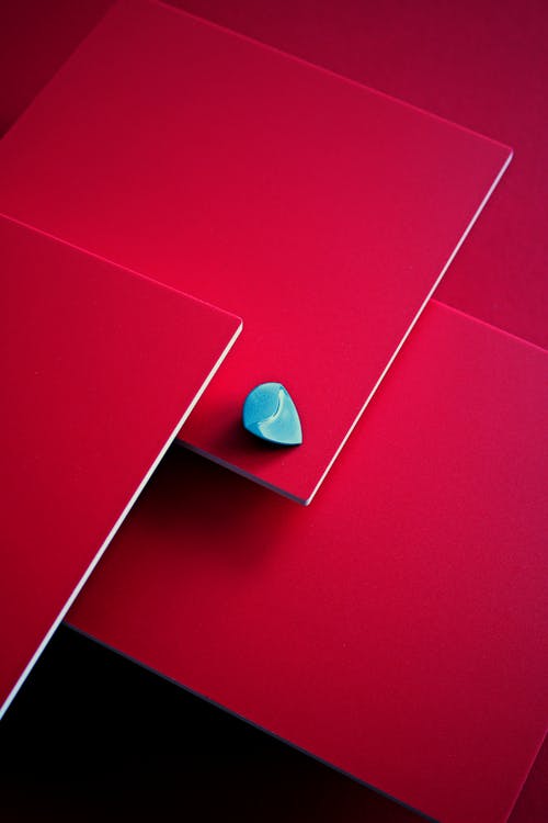 Close-up of a Guitar Pick Lying on Pink Background
