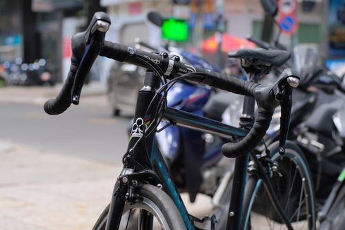 Free Detailed view of a racing bicycle in an urban street setting for dynamic transportation imagery. Stock Photo
