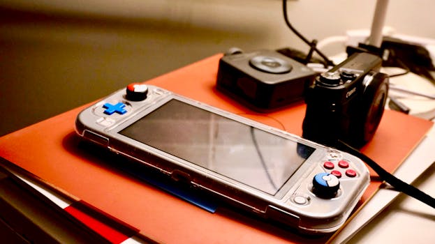 A portable gaming console beside a digital camera showcases modern entertainment and technology setup.