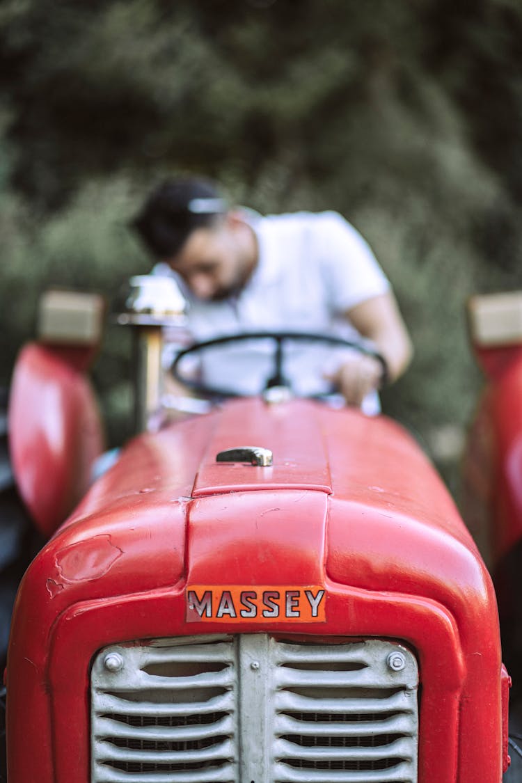 Man Sitting In Red Massey Ferguson Tractor