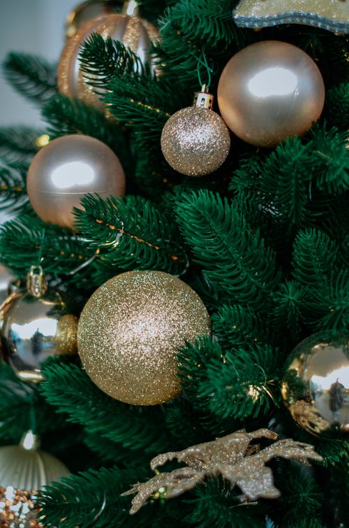 Free Close-up of a Christmas tree adorned with gold and glittering baubles, perfect for holiday spirit. Stock Photo