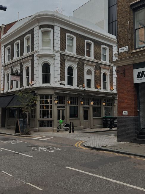 Classic architecture on a quiet London street corner with townhouses and bicycles.