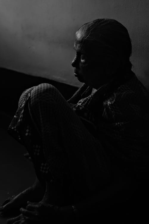 Silhouette of a Person Sitting in the Corner