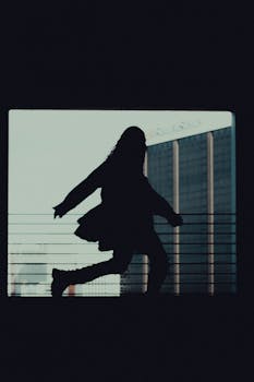 Silhouette of a woman running against a cityscape background, creating a dynamic urban scene.