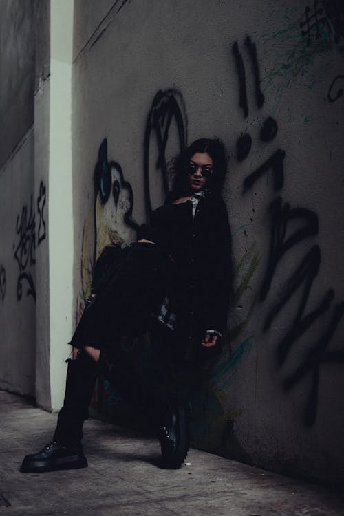Woman with Sunglasses Posing by Wall with Graffiti