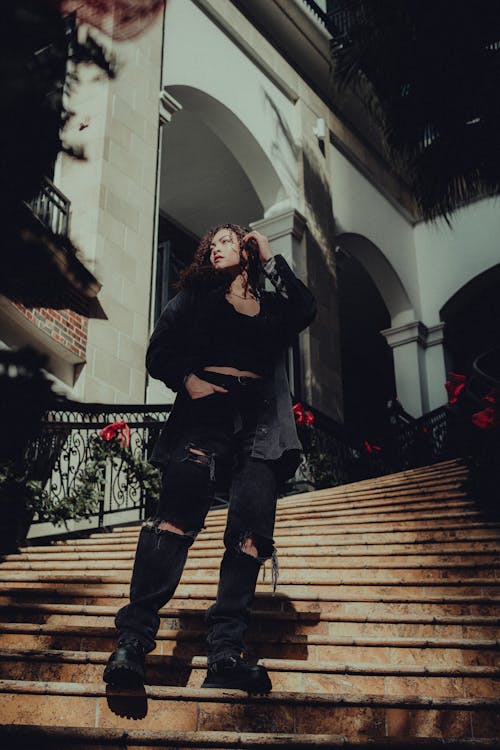 Brunette Woman Posing with Hand in Pocket on Stairs