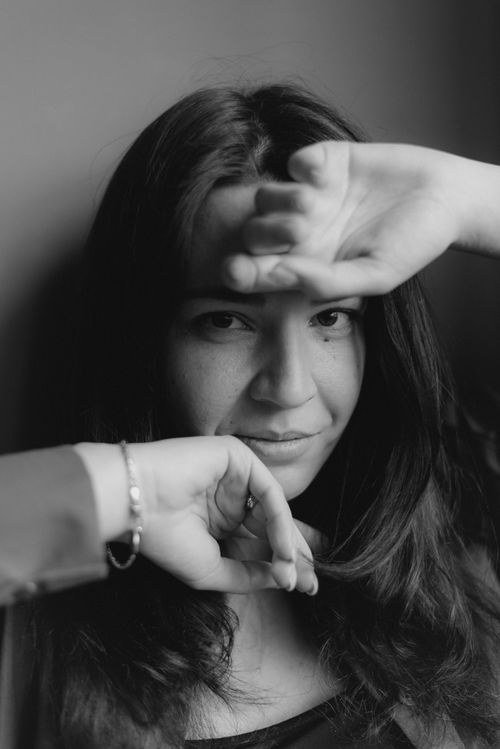 Free Artistic black and white portrait of a woman posing expressively with arms framing her face. Stock Photo