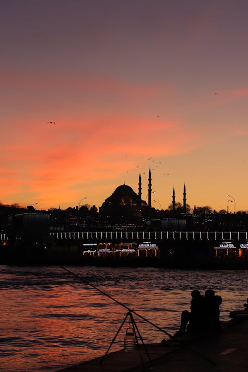 Silhouette of Mosque on Coast near Sea on Sunset