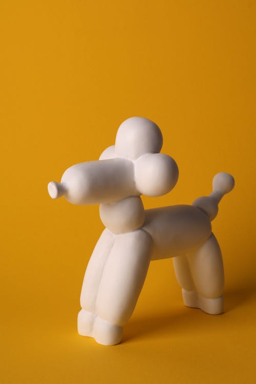 White Dog Figurine on Yellow Background