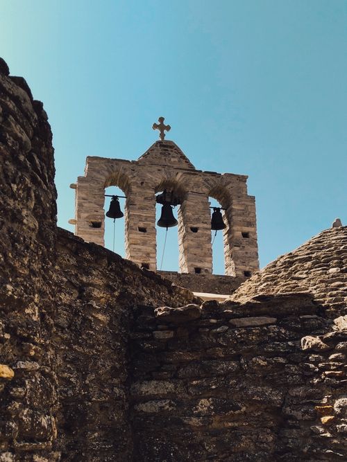 Free Ancient stone monastery featuring historic bell towers in Naxos, Greece, under a clear blue sky. Stock Photo