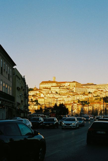 Street scene of Coimbra, Portugal, capturing the historic architecture basked in golden light.