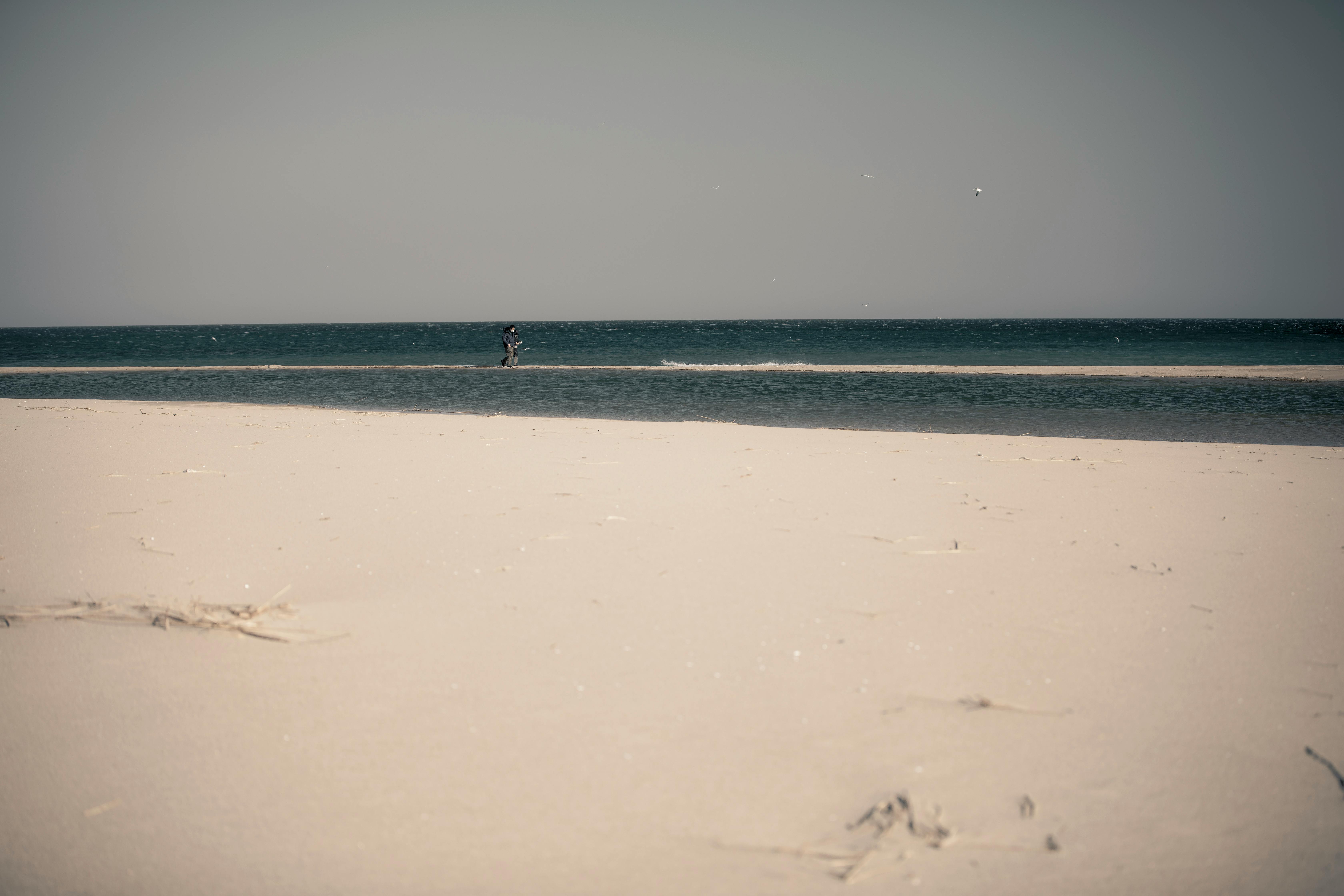 A tranquil beach scene in South Korea with sand and sea under a clear sky.
