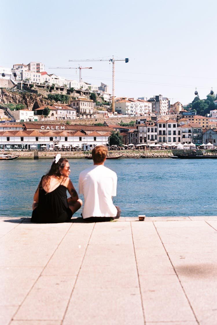 A Couple Sitting By The Water 