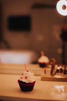 A tasty cupcake with icing and a candle, perfect for celebrations, captured in warm lighting.