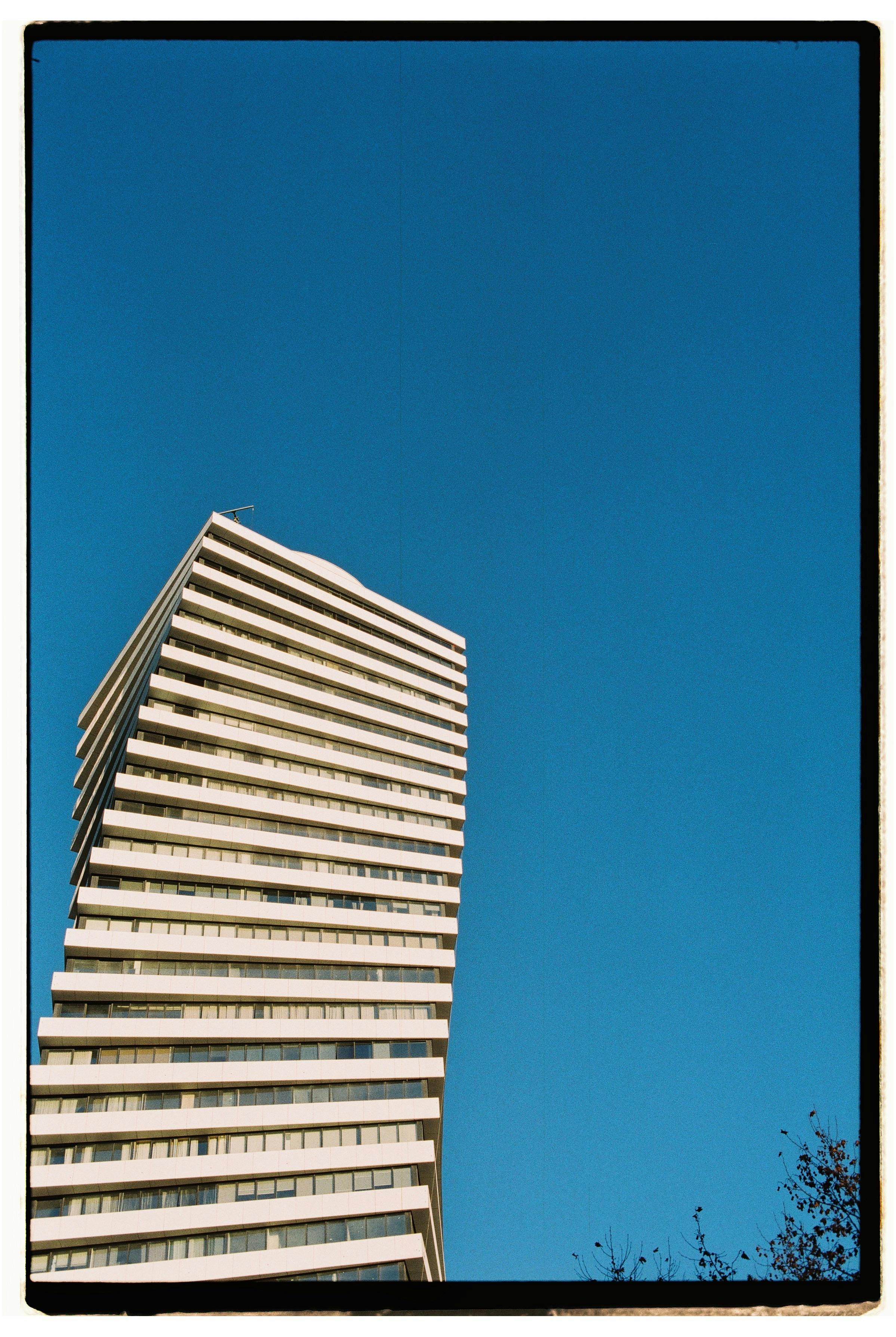 A unique modern skyscraper against a clear blue sky in Tbilisi, Georgia.