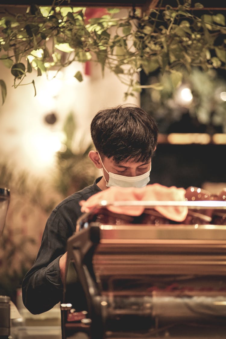 Candid Shot Of A Barista In A Face Mask Making Coffee 