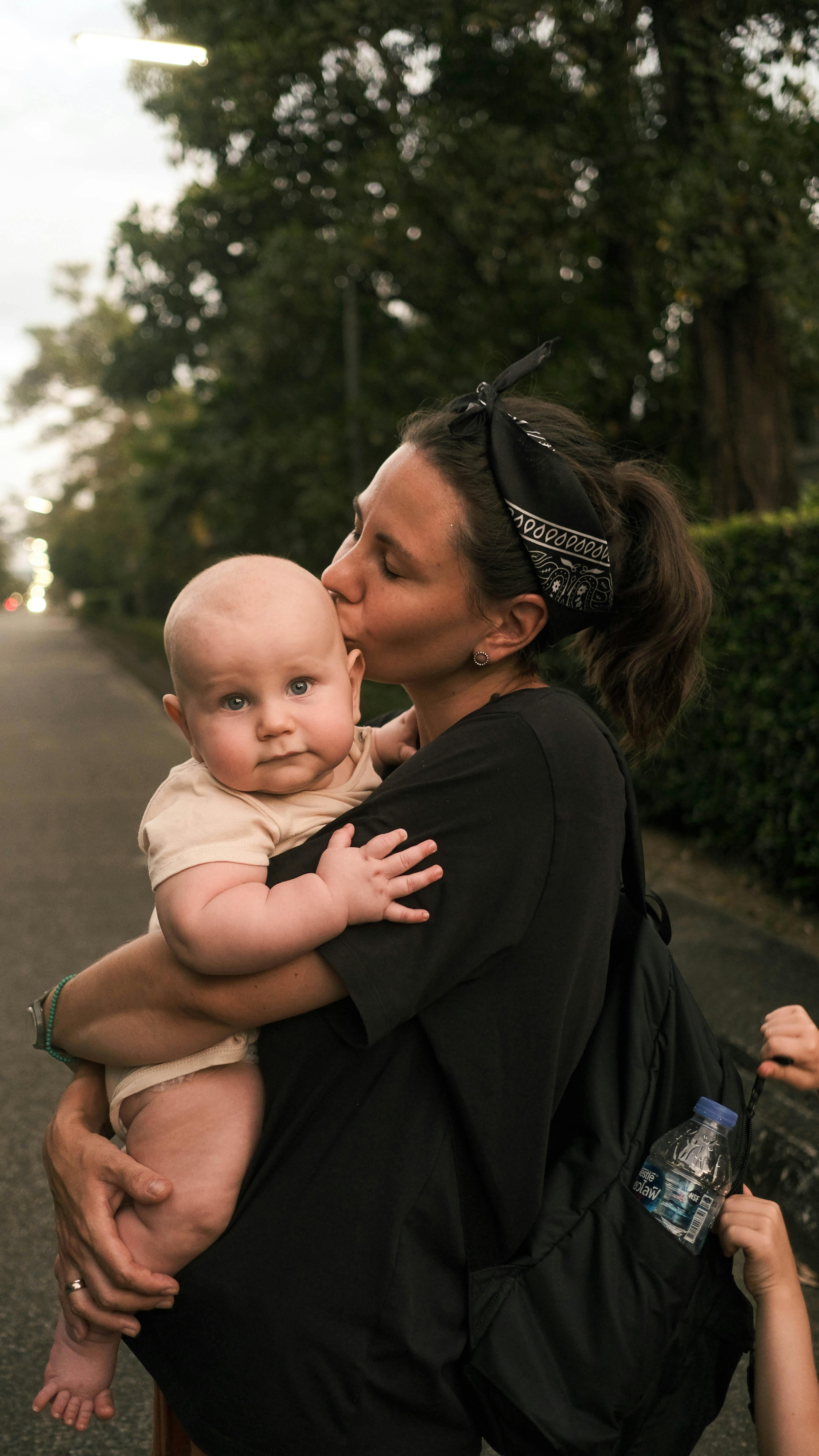 a mother kissing her baby