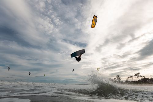 Free Energetic kiteboarding scene capturing the thrill and motion of water sports on open ocean waves. Stock Photo