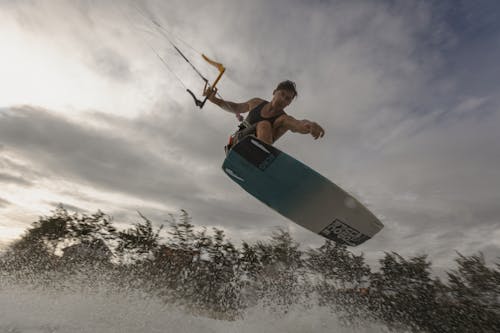 Low-Angle Shot of a Man Kitesurfing in Midair