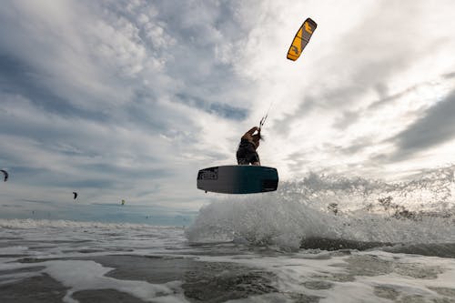 Low-Angle Shot of a Man Kiteboarding in the Sea