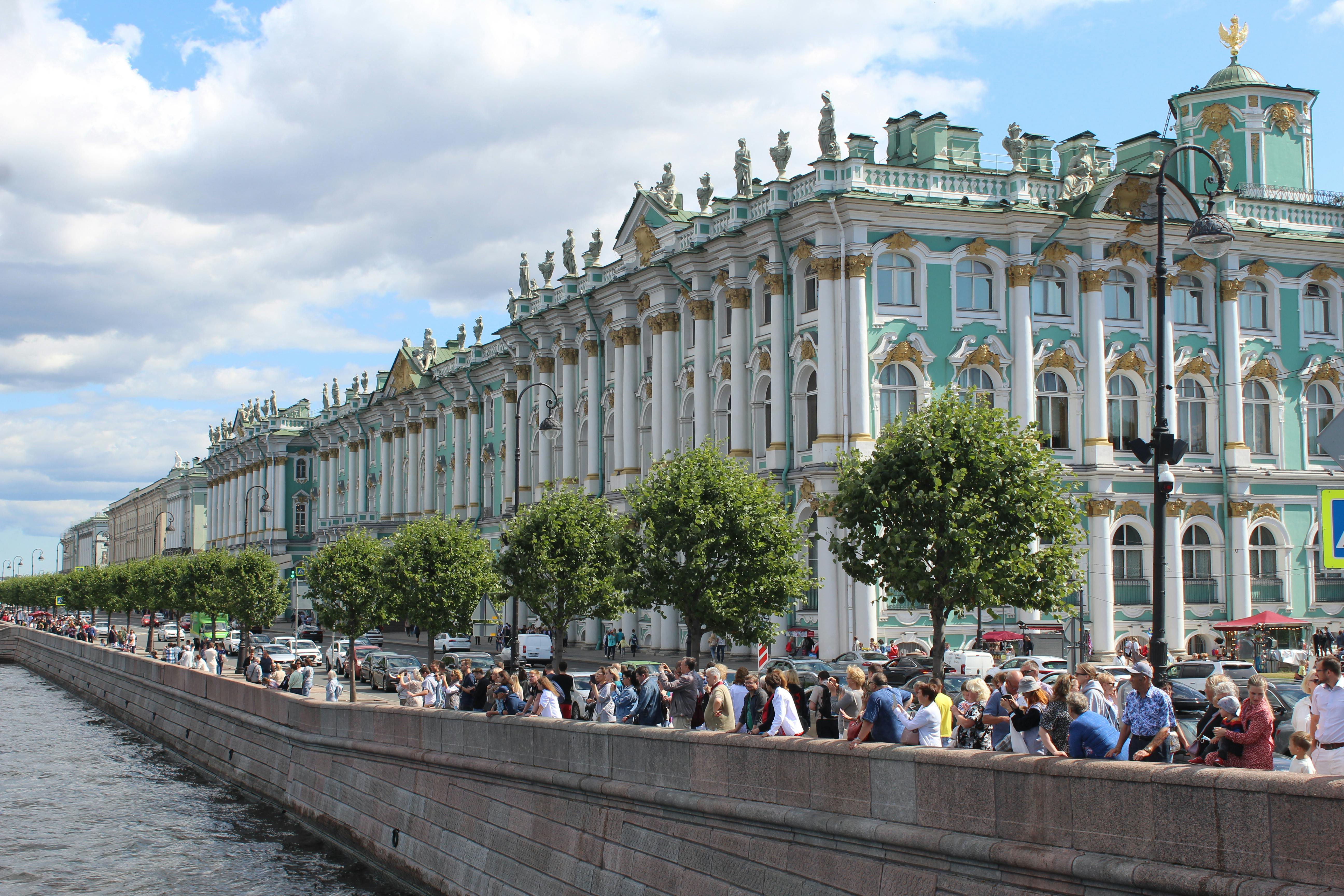 Explore the vibrant scene at Saint Petersburg's iconic Winter Palace on a sunny day.