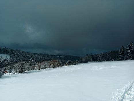 Scenic winter landscape in Sapois, France with snowy fields under an overcast sky.