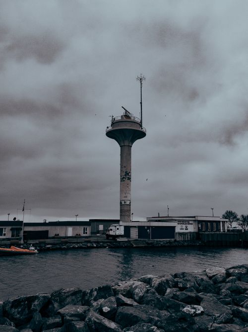 Free Moody view of a seaside observation tower under cloudy skies during twilight. Stock Photo