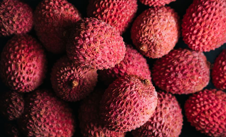 Vibrant close-up of fresh ripe lychees with textured skin, showcasing their natural color.