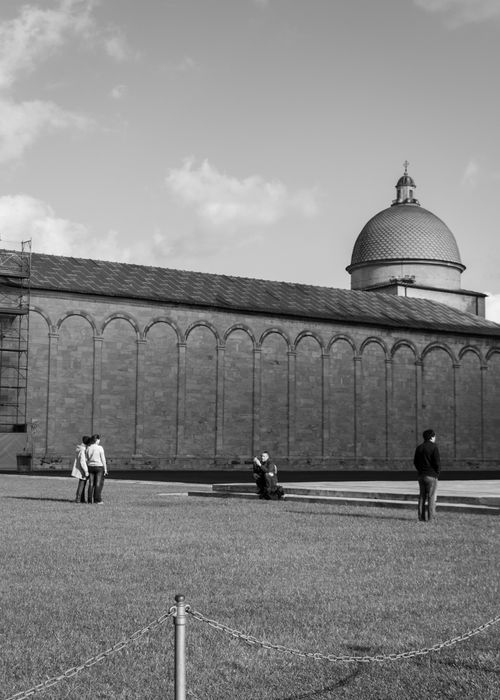 Free A serene black and white photo of Pisa's architectural landmark with visitors enjoying the view. Stock Photo