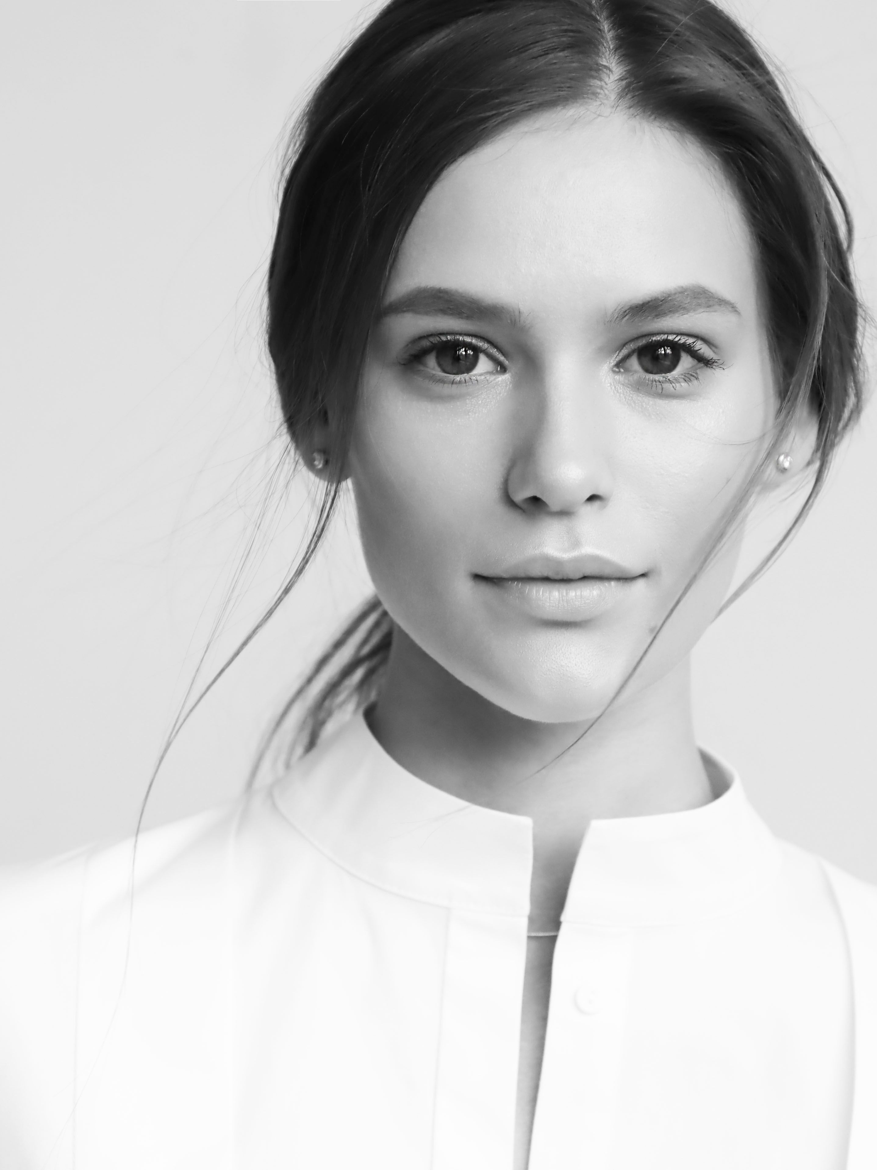 Minimalist black and white portrait of a young woman with a serene expression.