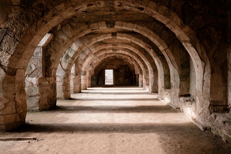 Sandstone vaults receding down a colonnade — photo by Kaan Keskin on Pexels