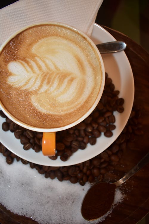 Free Coffee with Latte Art on the Background of Coffee Beans  Stock Photo