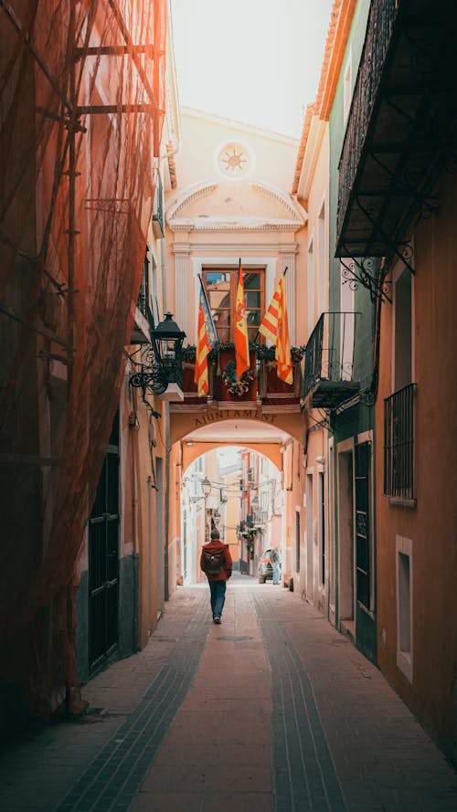 Back View of a Pedestrian Walking in the Narrow Streets of Old Town Villajoyosa, Alicante, Spain 
