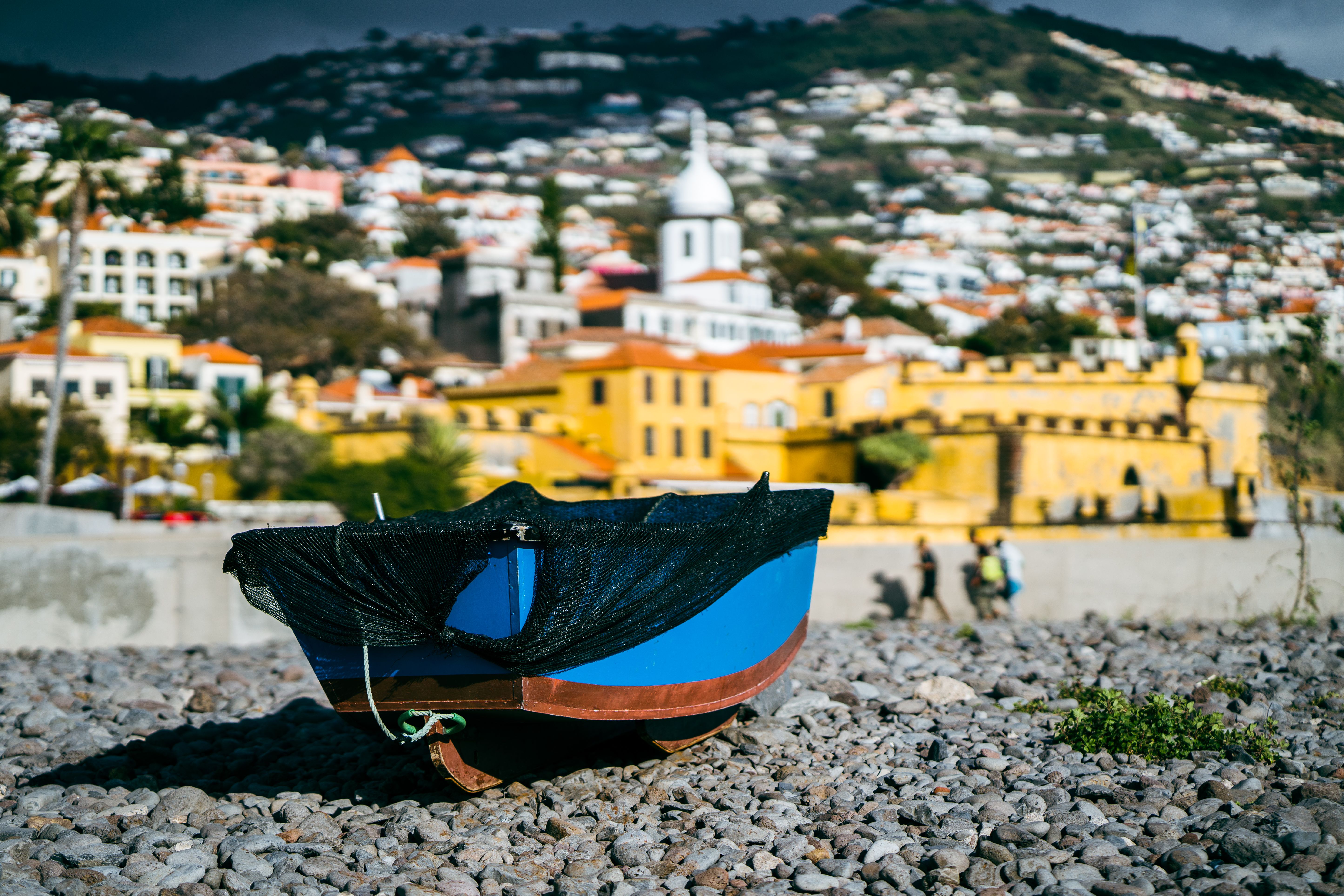 Fishing boats on the sand at Praia da Ribeira with the old town of Cascais behind