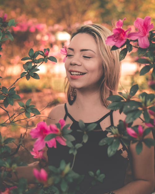 Blonde Woman Posing among Flowers