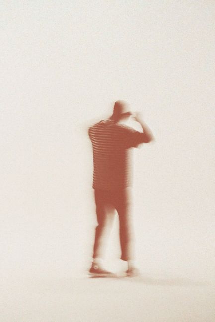 Abstract blurred image capturing the silhouette of a person in motion, evoking a sense of mystery and movement.
