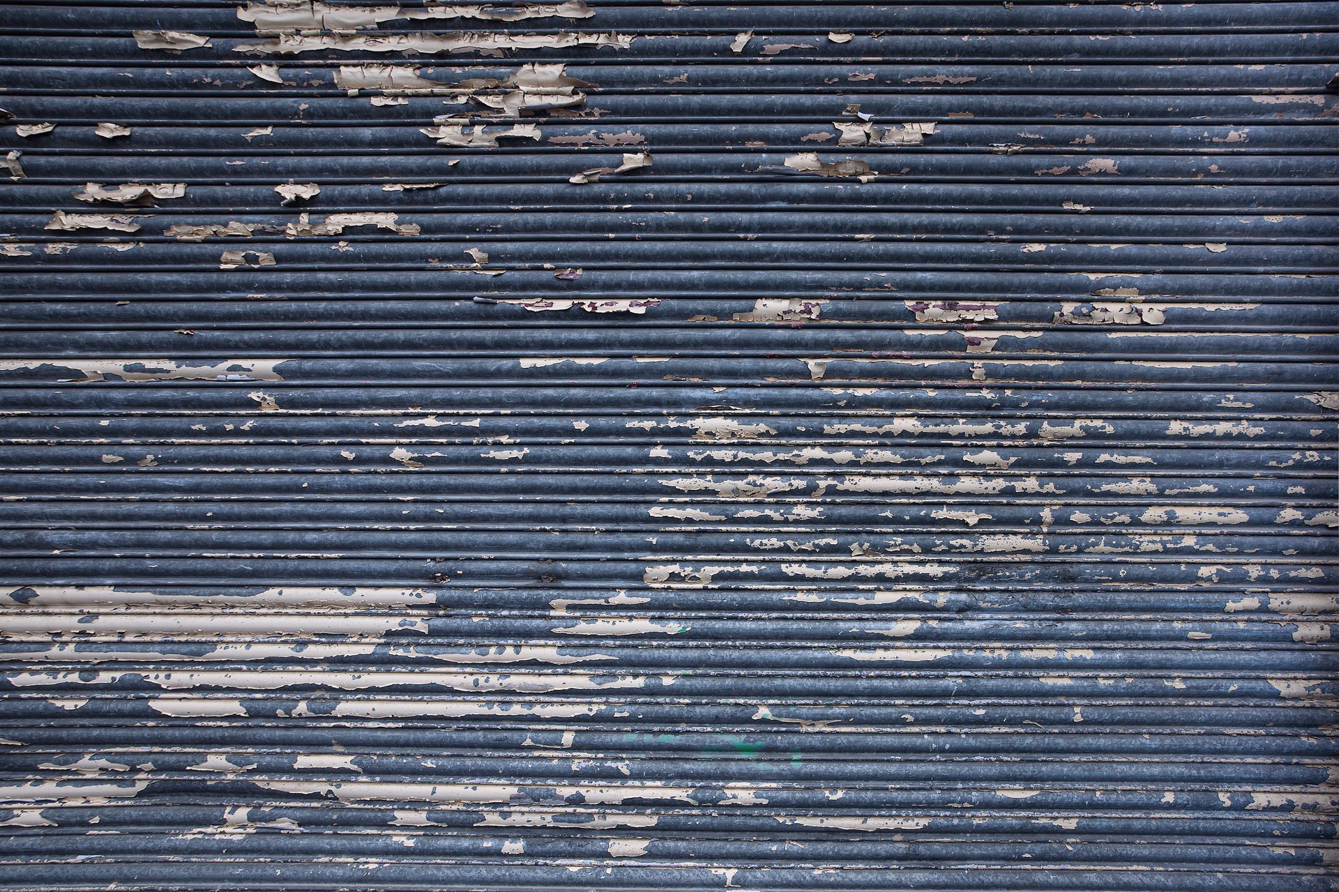 Detailed texture of a weathered, rusty garage door perfect for industrial backgrounds.
