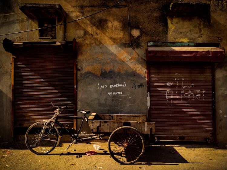 Bike With Carriage Near Abandoned Rustic Building