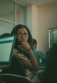 A young woman in a classroom setting using laptops for studying and education.